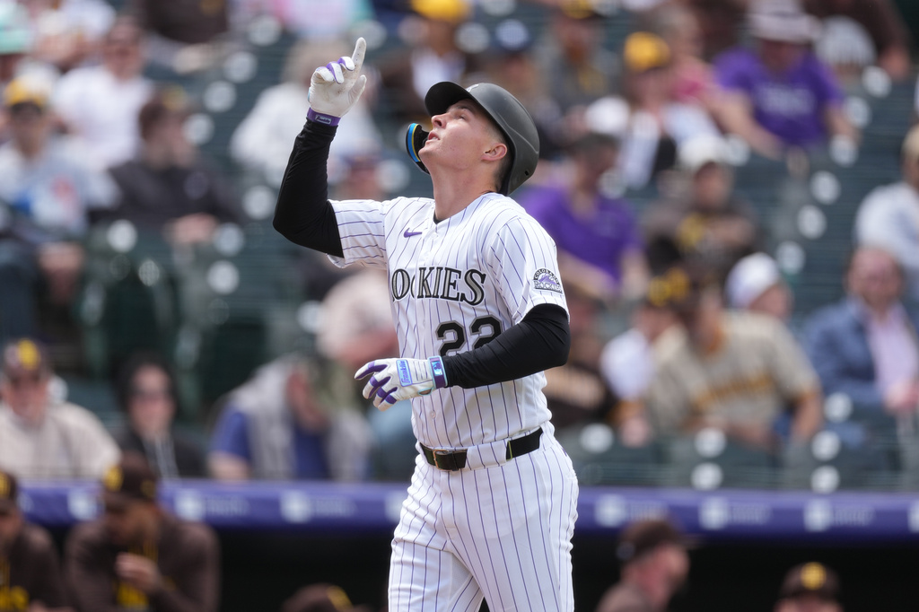 Colorado Rockies' Mickey Moniak gestures as he crosses home plate after hitting a solo home run off San Diego Padres starting pitcher Matt Waldron in the first inning of a baseball game Thursday, April 23, 2026, in Denver. (AP Photo/David Zalubowski)