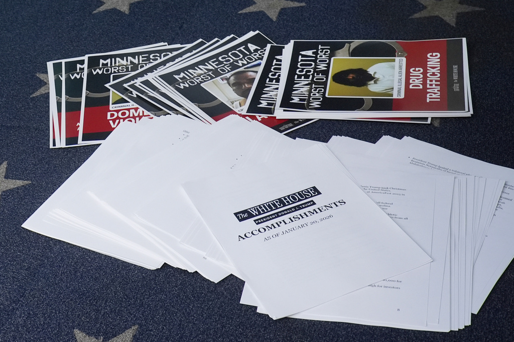 Documents lie on the briefing room floor as President Donald Trump speaks with reporters in the James Brady Press Briefing Room at the White House, Tuesday, Jan. 20, 2026, in Washington. (AP Photo/Alex Brandon)