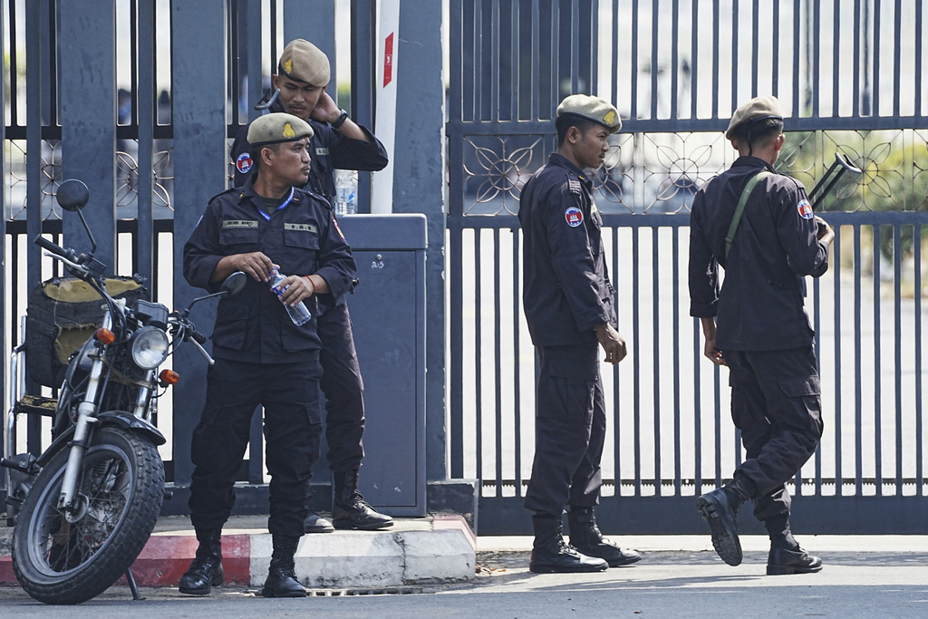 Cambodian police officers stand guard as they wait for 18 soldiers released after being captured and held by the Thai army, at former Phnom Penh International Airport in Phnom Penh, Cambodia, Wednesday, Dec. 31, 2025. (AP Photo/Heng Sinith)