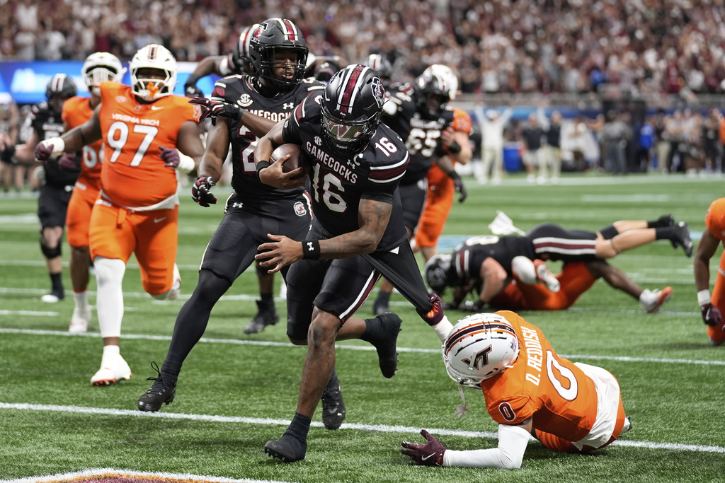 South Carolina quarterback LaNorris Sellers (16) scores against Virginia Tech safety Quentin Reddish (0) during an NCAA college football game, Sunday, Aug. 31, 2025, in Atlanta. (AP Photo/Brynn Anderson)