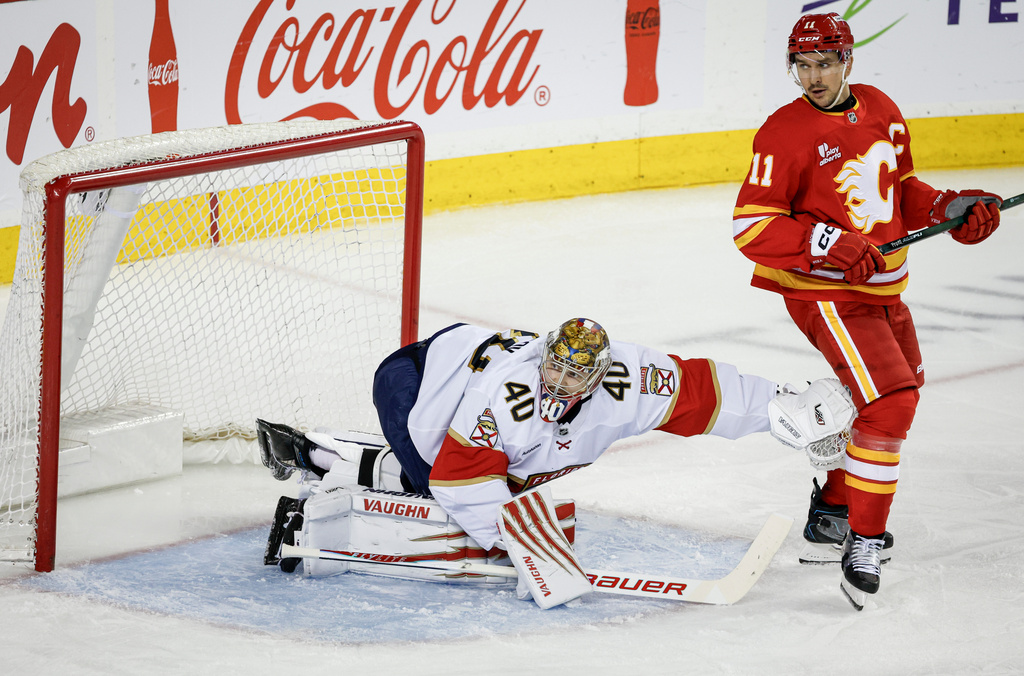 Florida Panthers goalie Daniil Tarasov, left, shoves Calgary Flames' Mikael Backlund, right, away from the crease during third-period NHL hockey game action in Calgary, Alberta, Friday, March 20, 2026. (Jeff McIntosh/The Canadian Press via AP)