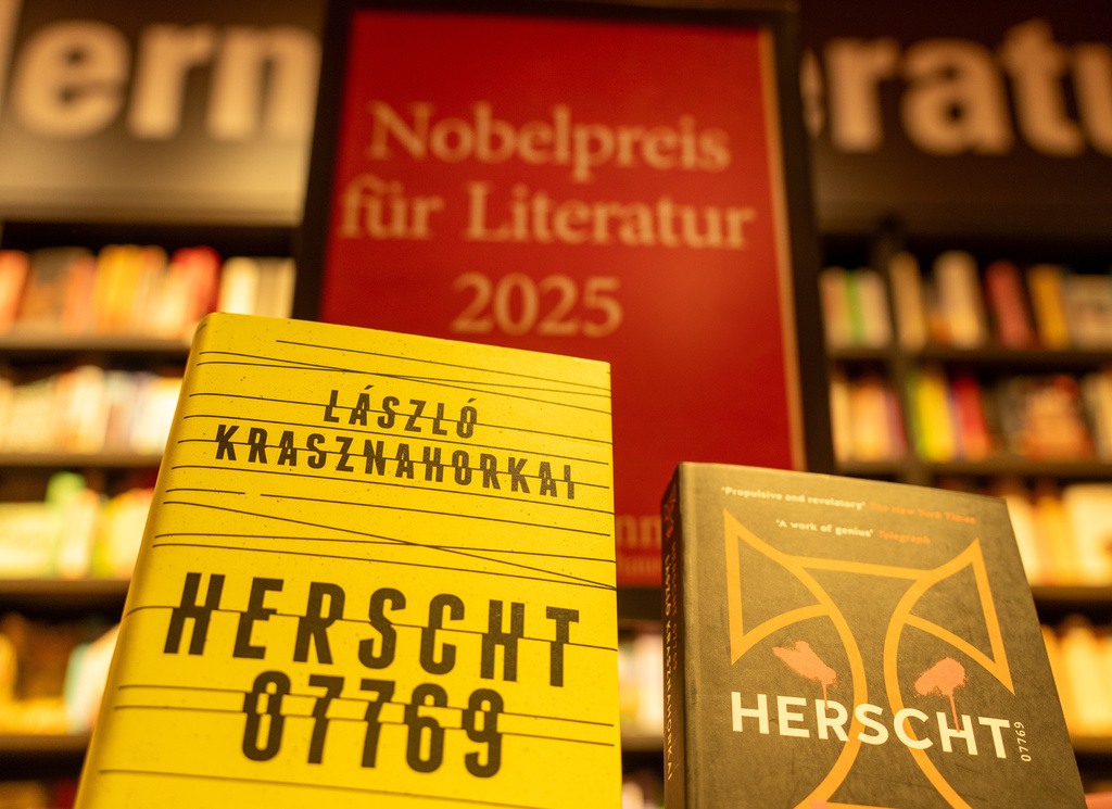 Books by Hungarian writer Laszlo Krasznahorkai are displayed in front of a stand with the inscription "Nobel Prize for Literature 2025" in Berlin's Dussmann cultural department store in Berlin, Germany, Thursday, Oct. 9, 2025. (Soeren Stache/dpa via AP)
