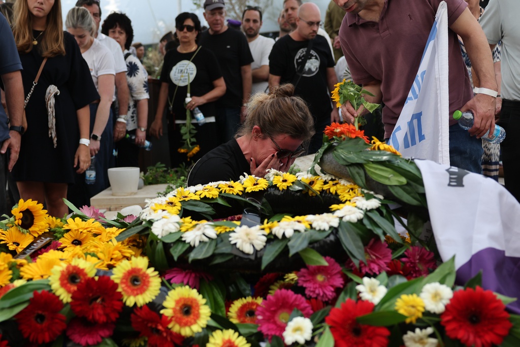People mourn at the grave of Hadar Goldin an Israeli soldier killed in Gaza in 2014 and whose body had been held there until it was released Sunday, during his funeral in Kfar Saba, Israel, Tuesday, Nov. 11, 2025. (Abir Sultan/Pool via AP)