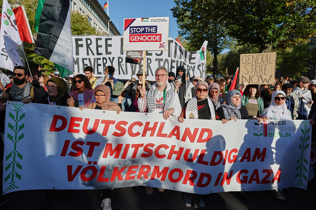 People hold a banner, reading "Germany is complicit in the genocide in Gaza" during a mass demonstration called "All Eyes on Gaza" in support of Palestinians in Berlin, Germany, Saturday, Sept. 27, 2025. (AP Photo/Christoph Soeder)