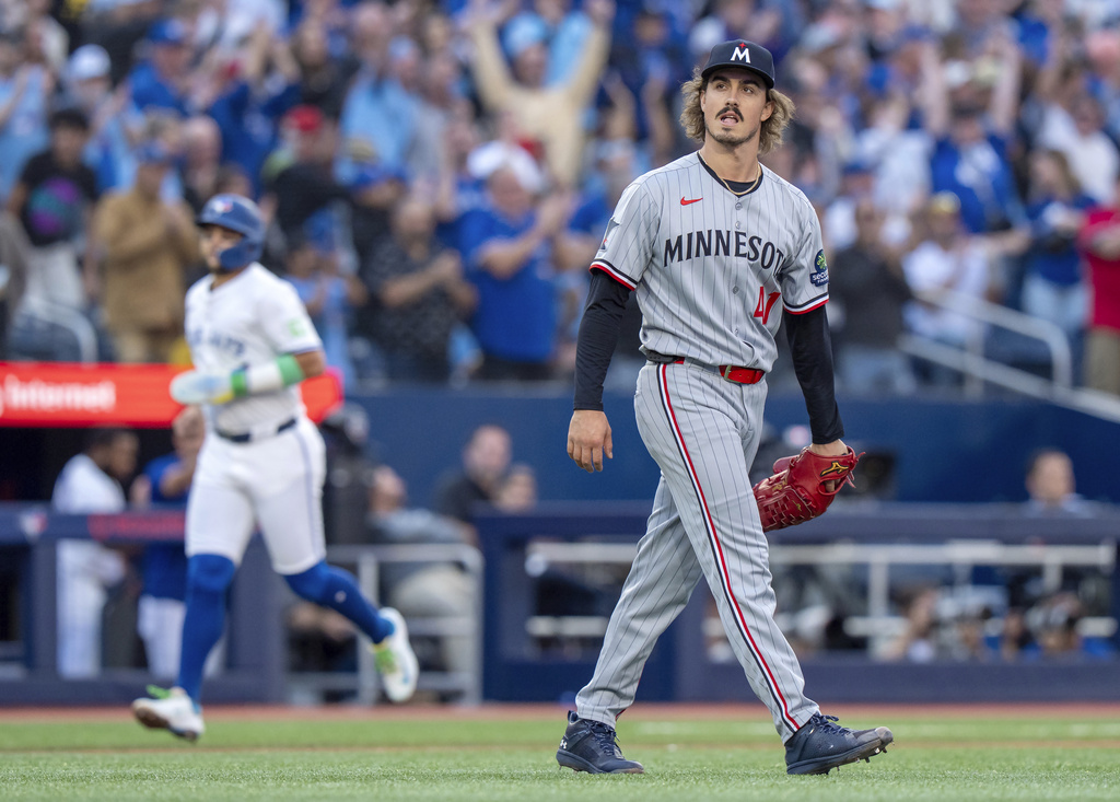 Minnesota Twins starting pitcher Joe Ryan, right, reacts as Toronto Blue Jays' Bo Bichette rounds the bases on Blue Jays' Alejandro Kirk's two-run home run in first-inning baseball game action in Toronto, Monday, Aug. 25, 2025. (Frank Gunn/The Canadian Press via AP)
