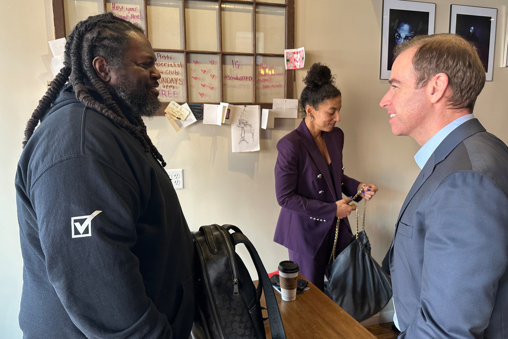 Luke Bronin, former mayor of Hartford, Conn., who is challenging Rep. John Larson, D-Conn., in the 2026 election primary, right, speaks with James Jeter, left, at the Semilla Cafe and Studio in Hartford on Jan. 22, 2026. (AP Photo/Susan Haigh)
