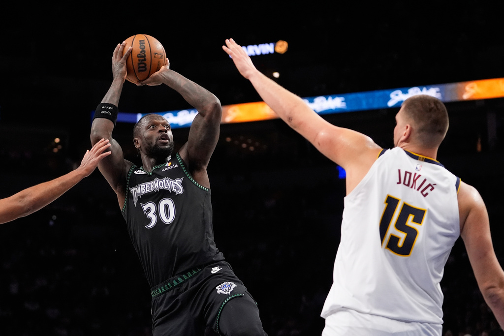 Minnesota Timberwolves forward Julius Randle (30) looks to shoot over Denver Nuggets center Nikola Jokic (15) during the first half of an NBA basketball game, Monday, Oct. 27, 2025, in Minneapolis. (AP Photo/Abbie Parr)
