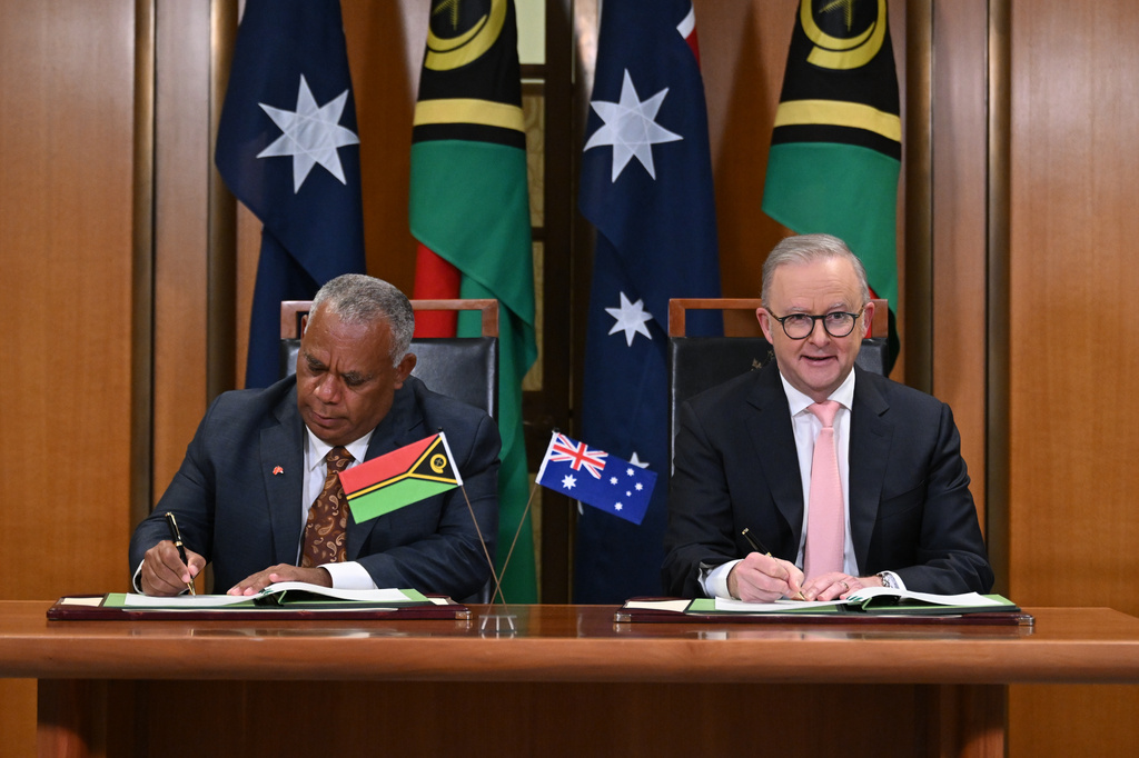 Prime Minister of Vanuatu Jotham Napat, left, and Australian Prime Minister Anthony Albanese sign the Nakamal agreement at Parliament House in Canberra, Monday, June 29, 2026. (Lukas Coch/AAP Image via AP)