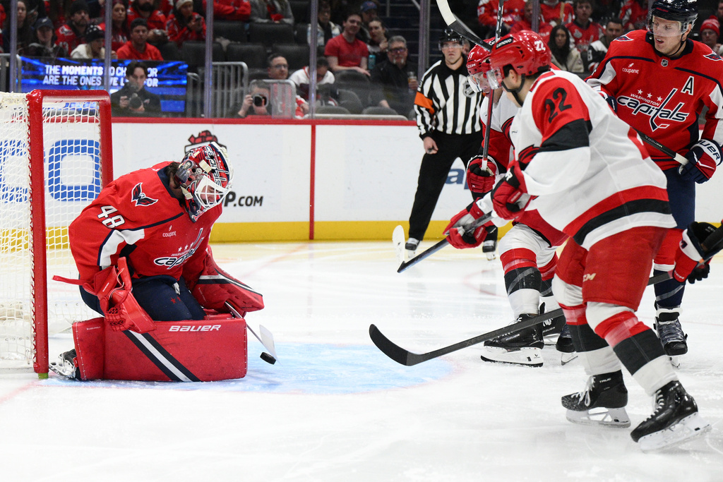Washington Capitals goaltender Logan Thompson (48) stops the puck against Carolina Hurricanes center Logan Stankoven (22) during the second period of an NHL hockey game, Thursday, Dec. 11, 2025, in Washington. (AP Photo/Nick Wass)