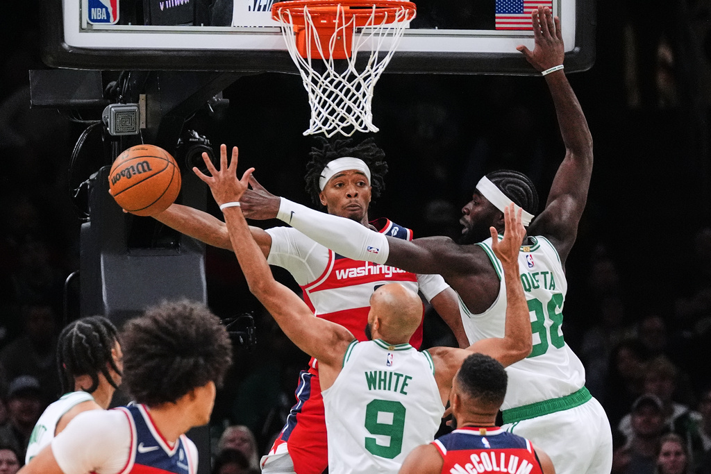 Washington Wizards guard Bilal Coulibaly, left, passes the ball while pressured by Boston Celtics center Neemias Queta (88) during the first half of an NBA basketball game, Wednesday, Nov. 5, 2025, in Boston. (AP Photo/Charles Krupa)