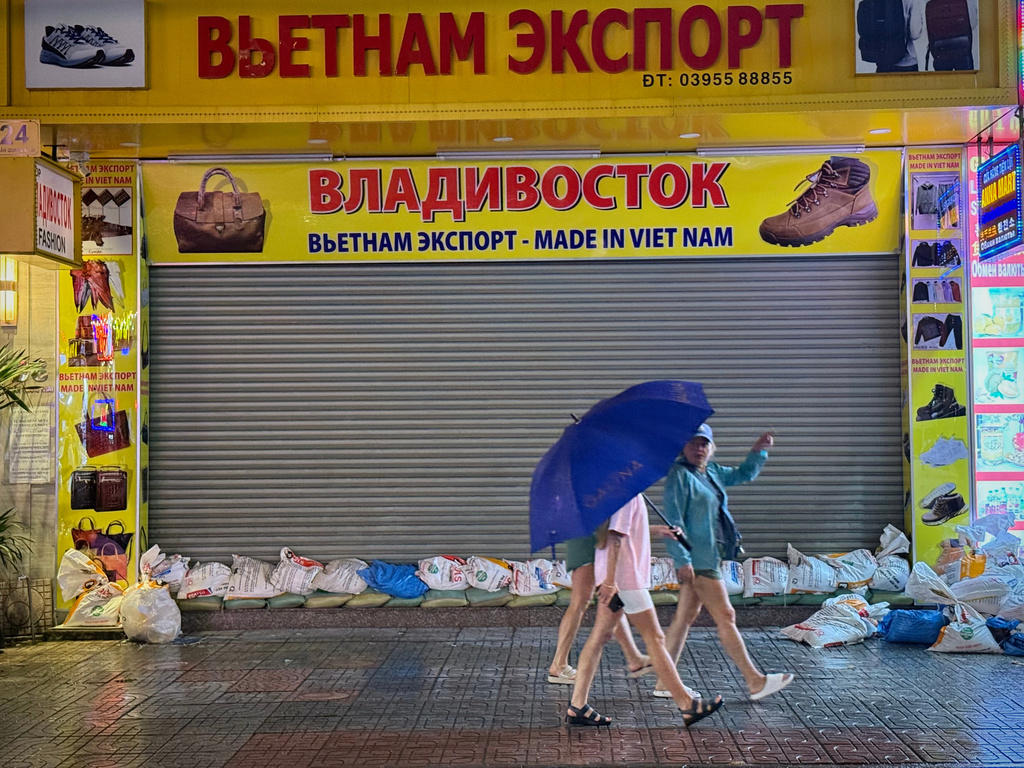 People walk past a closed shop due to Typhoon Kalmaegi in Khanh Hoa, Vietnam, Thursday, Nov. 6, 2025. (AP Photo/Hau Dinh)
