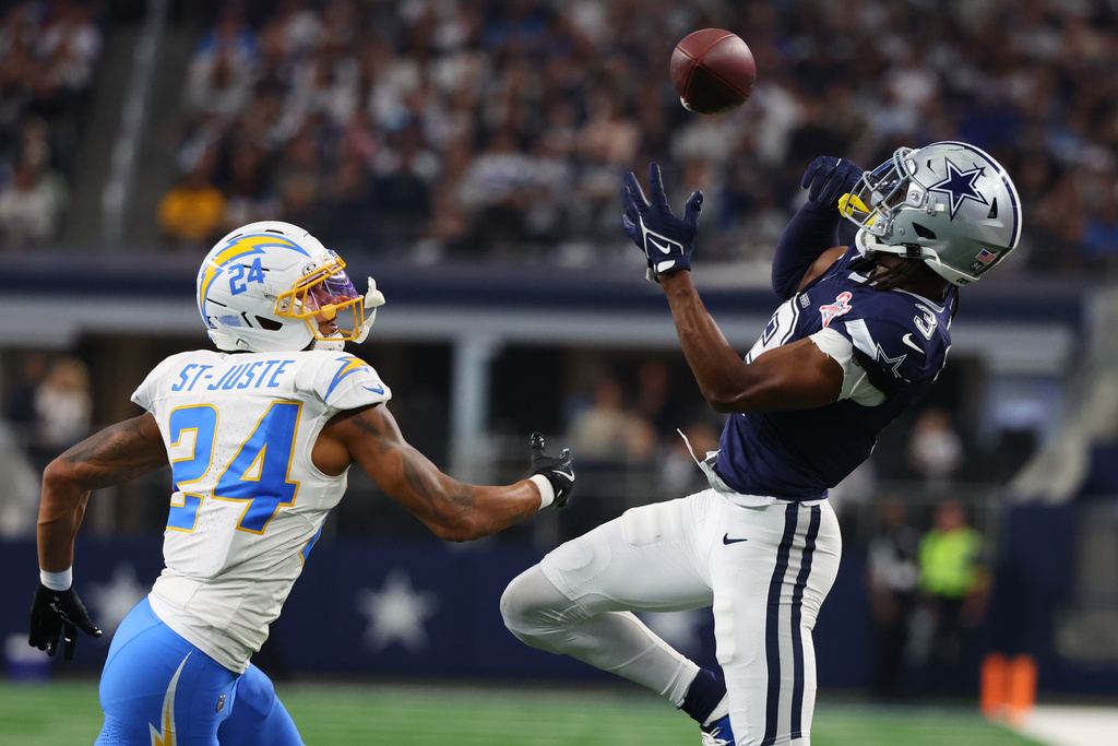 Dallas Cowboys wide receiver George Pickens (3) makes a catch next to Los Angeles Chargers cornerback Benjamin St-Juste (24) during the second half of an NFL football game Sunday, Dec. 21, 2025, in Arlington, Texas. (AP Photo/Richard W. Rodriguez)
