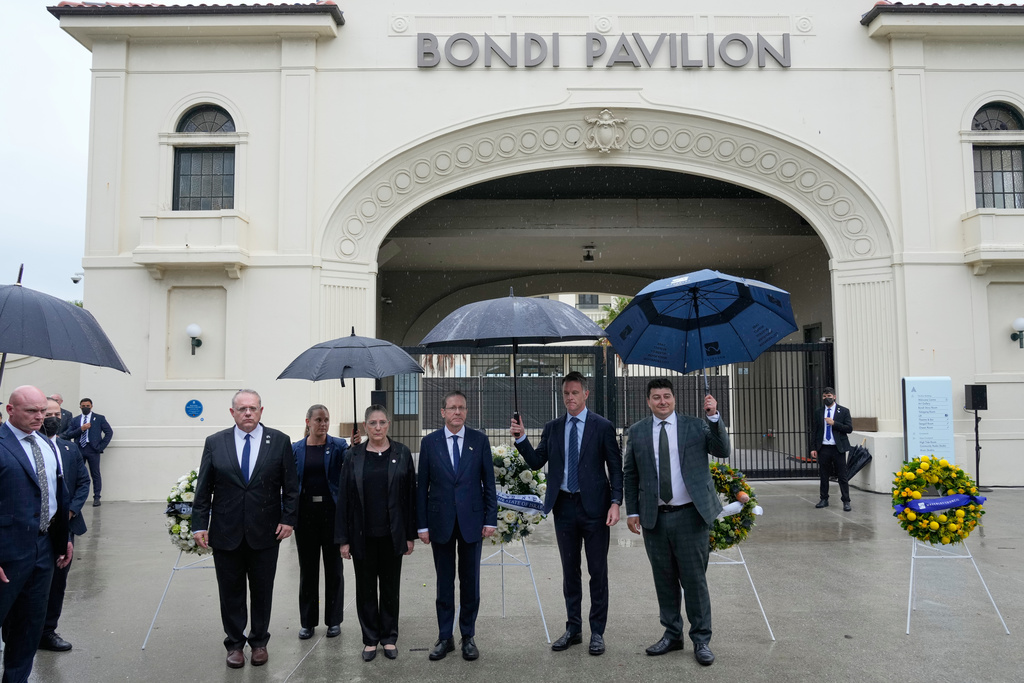 Israel's President Isaac Herzog, center right, visits Bondi Beach where the Dec. 2025 shooting took place, in Sydney, Monday, Feb. 9, 2026. (AP Photo/Rick Rycroft)