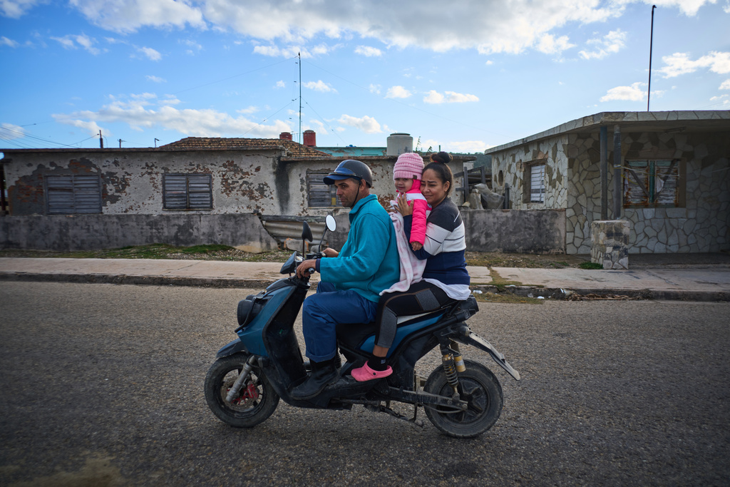 A family travels on their electric motorbike during a power cut in Santa Cruz del Santa Cruz del Norte, home to one of Cuba’s largest thermoelectric plants, Tuesday, Feb. 3, 2026. (AP Photo/Ramon Espinosa)