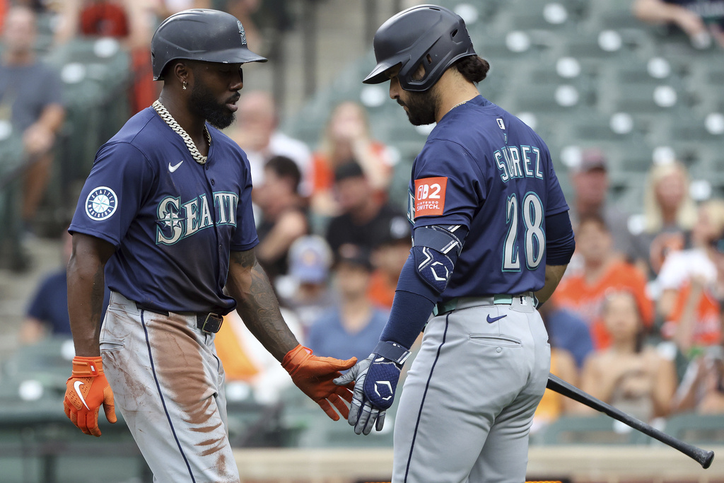 Seattle Mariners' Randy Arozarena scores and celebrates with Seattle Mariners' Eugenio Suarez during the first inning of a baseball game against the Baltimore Orioles, Tuesday, Aug. 12, 2025, in Baltimore. (AP Photo/Daniel Kucin Jr.)