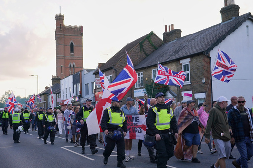 FILE - Police officers escort protesters near the Bell Hotel in Epping, London, Sunday, Aug. 31, 2025 after a temporary injunction that would have blocked asylum seekers from being housed at the hotel was overturned. (AP Photo/Alberto Pezzali, File) FILE - Police officers escort protesters near the Bell Hotel in Epping, London, Sunday, Aug. 31, 2025 after a temporary injunction that would have blocked asylum seekers from being housed at the hotel was overturned. (AP Photo/Alberto Pezzali, File)