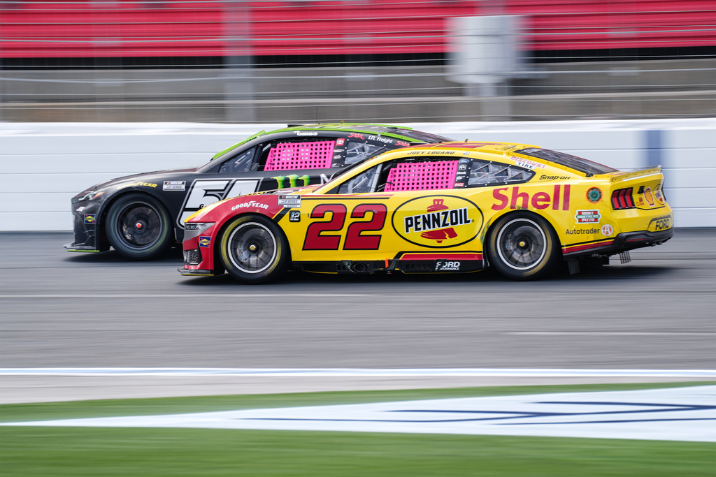 Joey Logano (22) looks to pass Ty Gibbs, left, during a NASCAR Cup Series auto race at Charlotte Motor Speedway, Sunday, Oct. 5, 2025, in Concord, N.C. (AP Photo/Matt Kelley)