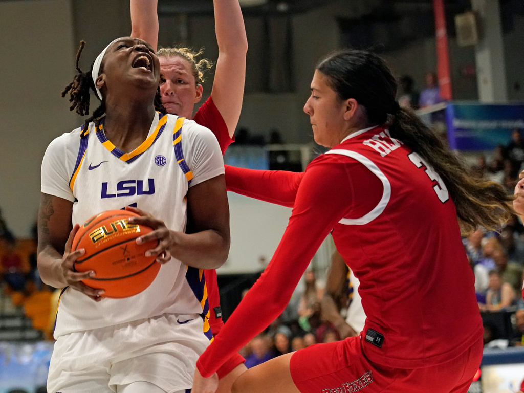 LSU forward Amiya Joyner, left front, drives the lane against Marist guard Justine Henry, right, and forward Karly Fischer , left back, during the second quarter of an NCAA college basketball game at the Paradise Jam tournament Friday, Nov. 28, 2025, in St. Thomas, U.S. Virgin Islands. (Bill Kiser/The Virgin Islands Daily News via AP)