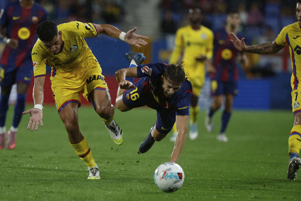 Getafe's Abdel Abqar fights for the ball against Barcelona's Fermin Lopez during a Spanish La Liga soccer match between FC Barcelona and Getafe at the Johan Cruyff stadium in Barcelona, Spain, Sunday, Sept. 21, 2025. (AP Photo/Joan Monfort)