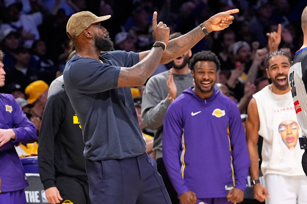 Los Angeles Lakers' LeBron James, left, and Bronny James, center, celebrate a San Antonio Spurs turnover during the second half of an NBA basketball game Wednesday, Nov. 5, 2025, in Los Angeles. (AP Photo/Mark J. Terrill)