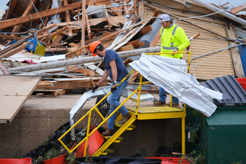 People clear debris following a storm in Mineral Wells, Texas, Wednesday, April 29, 2026. (AP Photo/Julio Cortez)