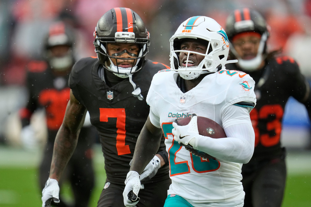 Miami Dolphins running back De'Von Achane (28) is chased by Cleveland Browns cornerback Tyson Campbell (7) in the first half of an NFL football game in Cleveland, Sunday, Oct. 19, 2025. (AP Photo/Sue Ogrocki)
