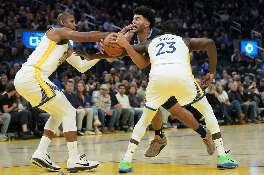 Memphis Grizzlies forward Cameron Boozer, middle, drives to the basket against Golden State Warriors center Al Horford, left, and forward/center Draymond Green during the first half of an NBA basketball game, Friday, Oct. 23, 2026, in San Francisco. (AP Photo/Jeff Chiu)