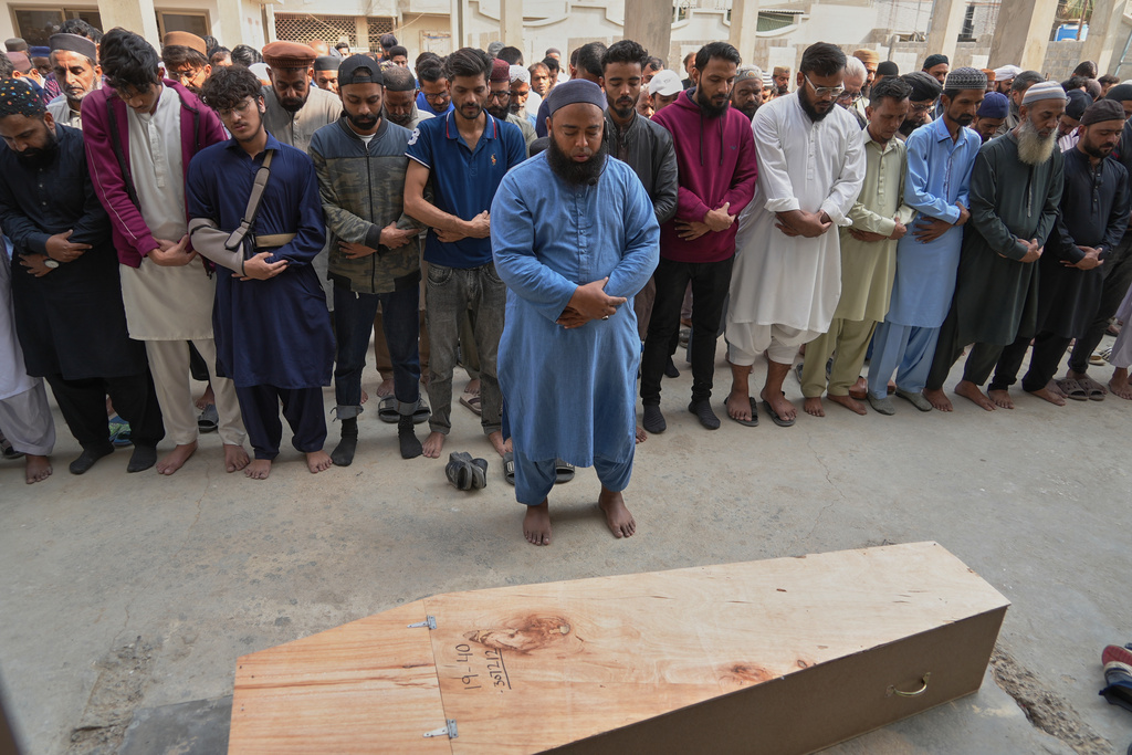 People offer funeral prayers of Shahroz Iqbal, who was killed in the shopping mall fire incident, in Karachi, Pakistan, Wednesday, Jan. 21, 2026. (AP Photo/Mohammad Farooq)
