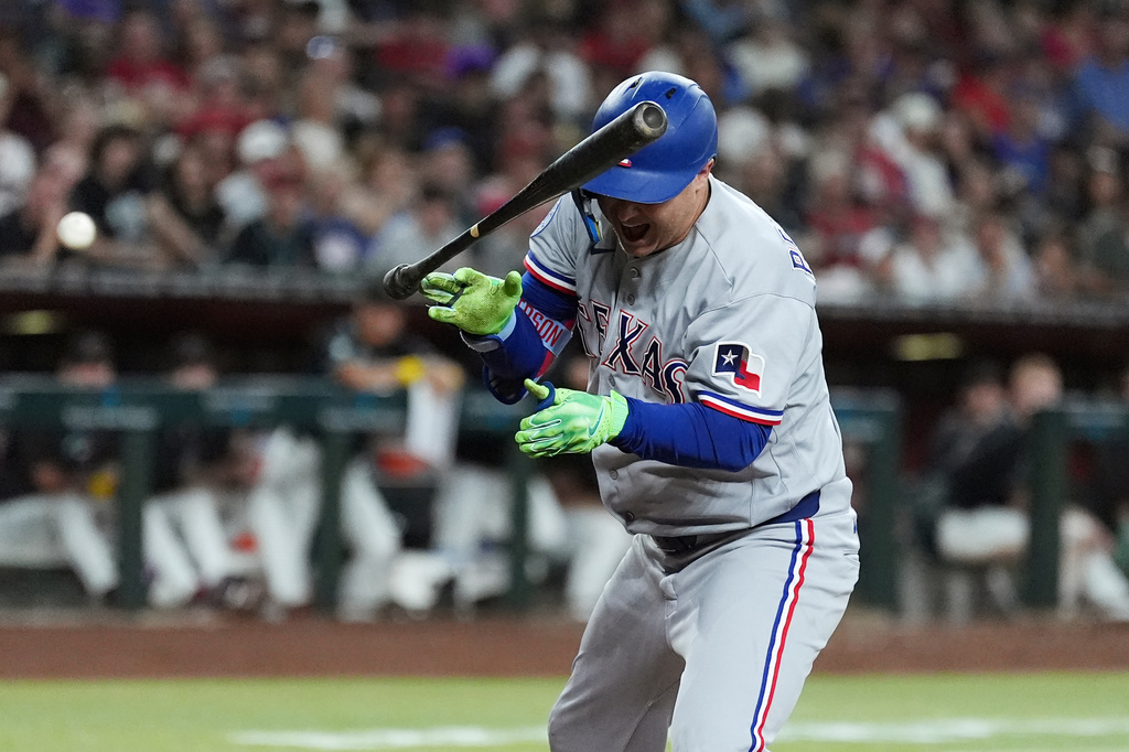 Texas Rangers designated hitter Joc Pederson reacts to being hit by a pitch against the Arizona Diamondbacks during the fifth inning of a baseball game, Saturday, Sept. 12, 2026, in Phoenix. (AP Photo/Ross D. Franklin)