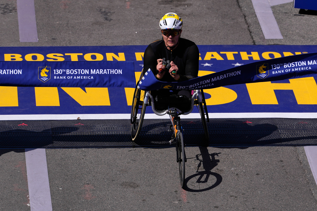 Eden Rainbow-Cooper, of Portsmouth, England, breaks the finish line tape to win the women's wheelchair division of the Boston Marathon, Monday, April 20, 2026, in Boston. (AP Photo/Charles Krupa)