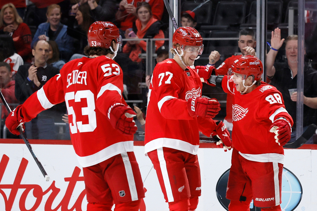Detroit Red Wings right wing Patrick Kane (88) celebrates with defenseman Simon Edvinsson (77) and defenseman Moritz Seider (53) after scoring a goal against the Philadelphia Flyers during the third period of an NHL hockey game Thursday, April 9, 2026, in Detroit. (AP Photo/Duane Burleson)