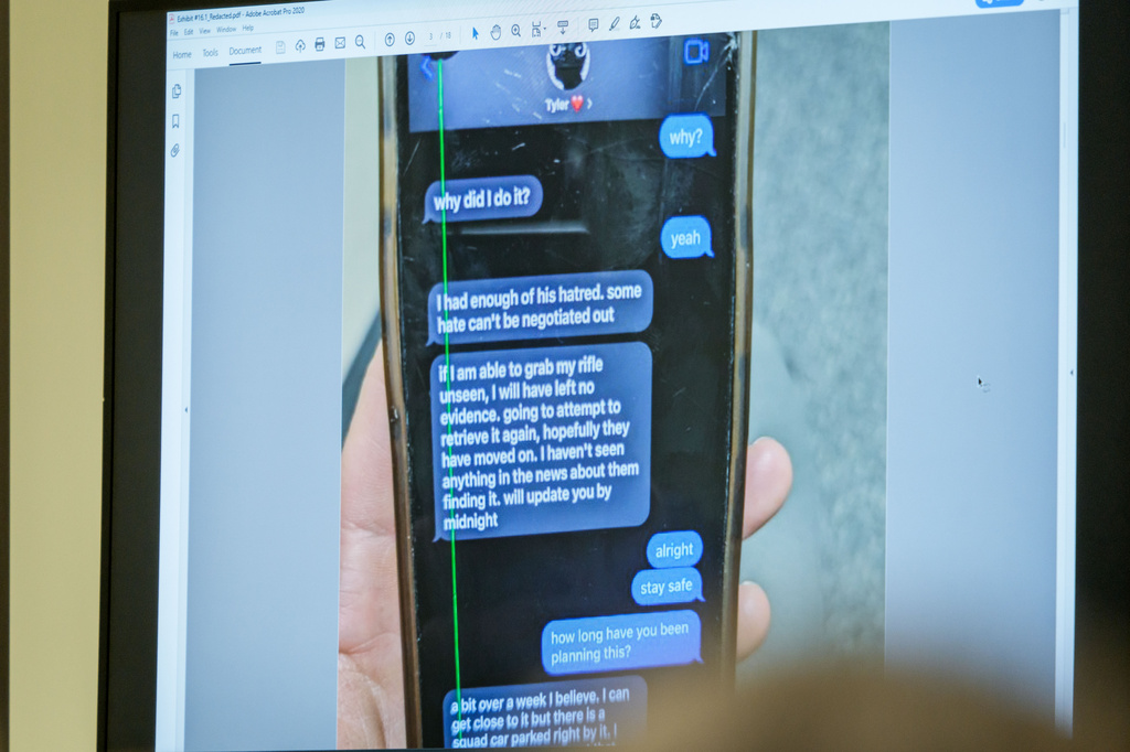 A photograph which prosecutors say shows a text message exchange between Tyler Robinson, who is accused in the fatal shooting of Charlie Kirk, and Robinson's roommate and romantic partner Lance Twiggs, is shown during a preliminary hearing at the Fourth District Courthouse in Provo, Utah, Thursday, July 9, 2026. (AP Photo/Spenser Heaps, Pool)