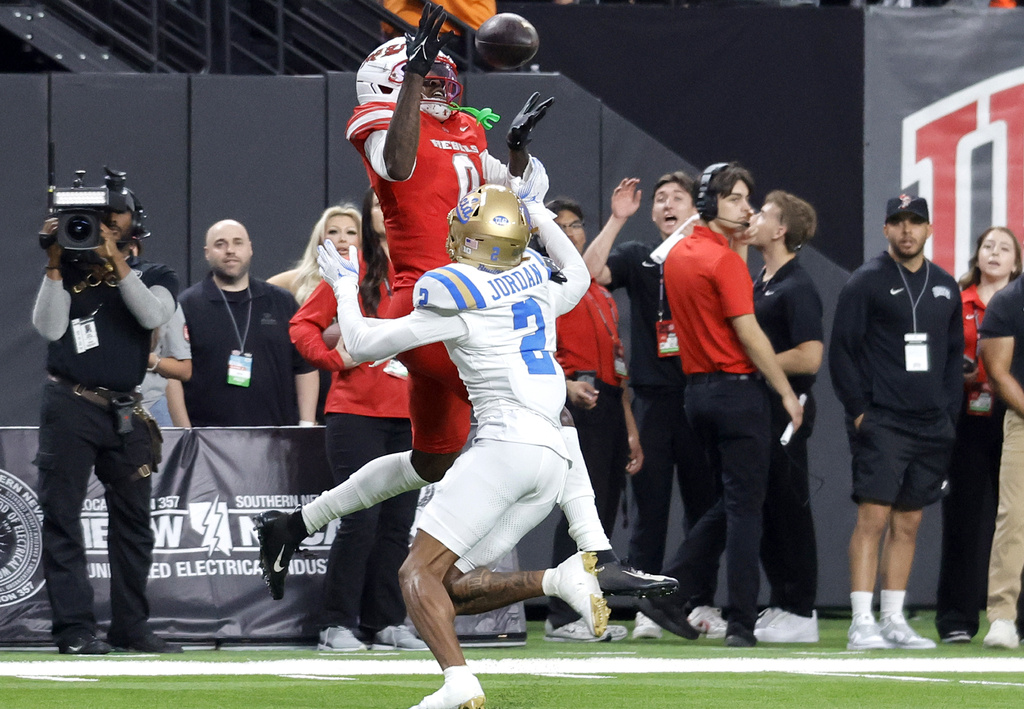 UNLV wide receiver Troy Omeire (0) catches a pass over UCLA defensive back Andre Jordan Jr. (2) and carries the ball into the end zone for a touchdown ball during an NCAA football game Saturday, Sept. 6, 2025, in Las Vegas. (Steve Marcus/Las Vegas Sun via AP)
