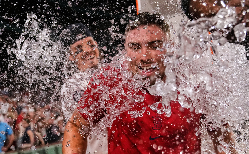 Boston Red Sox's Caleb Durbin, front, is doused by Jarren Duran after his winning RBI single during the 13th inning of a baseball game against the Chicago White Sox, Thursday, Aug. 6, 2026, in Boston. (AP Photo/Charles Krupa)