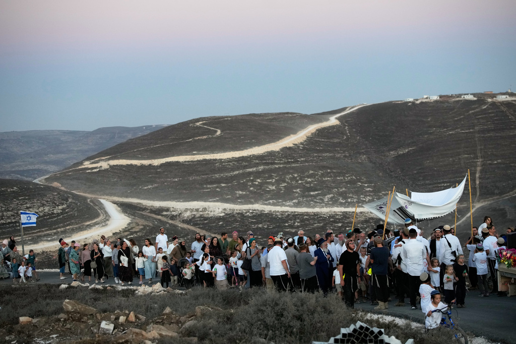 Israeli settlers celebrate the inauguration of a newly built synagogue at the occupied West Bank outpost of Homesh, Wednesday, Sept. 16, 2026. (AP Photo/Ohad Zwigenberg)