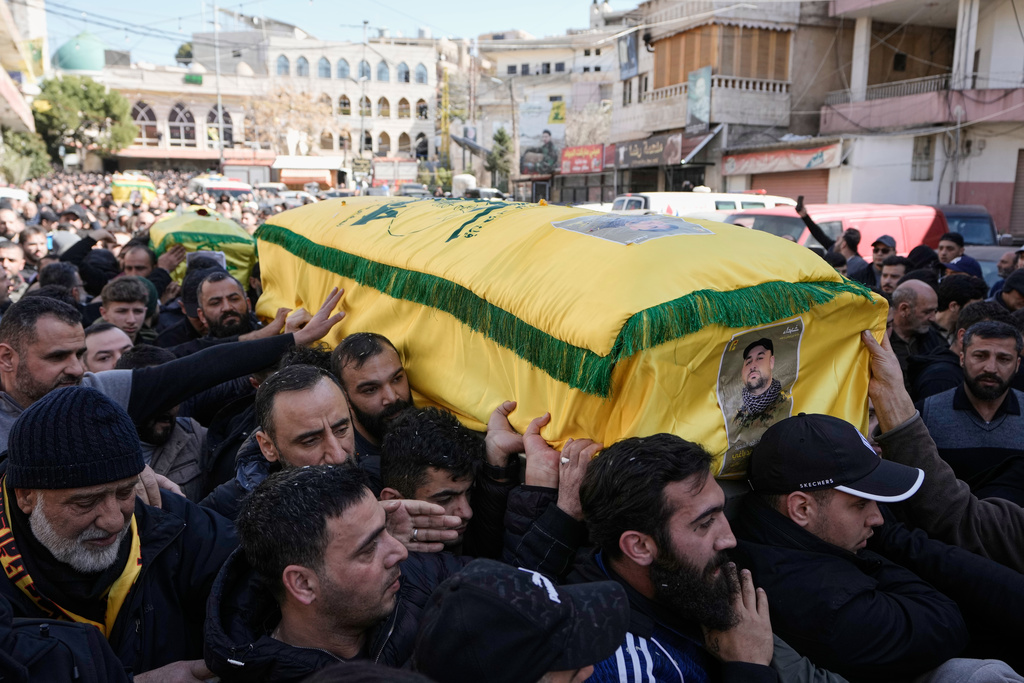 Mourners carry the coffins of three Hezbollah fighters killed in Friday's Israeli strikes during their funeral procession in the village of Nabi Sheet in eastern Lebanon, Saturday, Feb. 21, 2026. (AP Photo/Bilal Hussein)