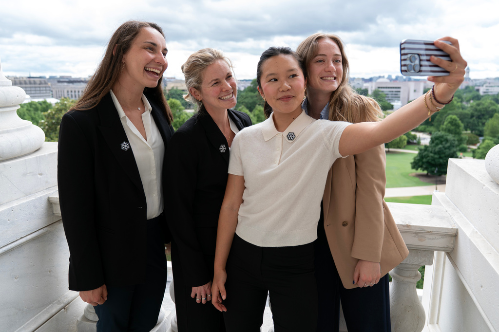 Olympians Julia Kern, from left, Jessie Diggins, Bea Kim and Olivia Giaccio, take a selfie from the Senate Minority Leader balcony during a meeting to advocate for clean air, clean water and a healthy planet on Capitol Hill, Tuesday, June 23, 2026, in Washington. (AP Photo/Jose Luis Magana)