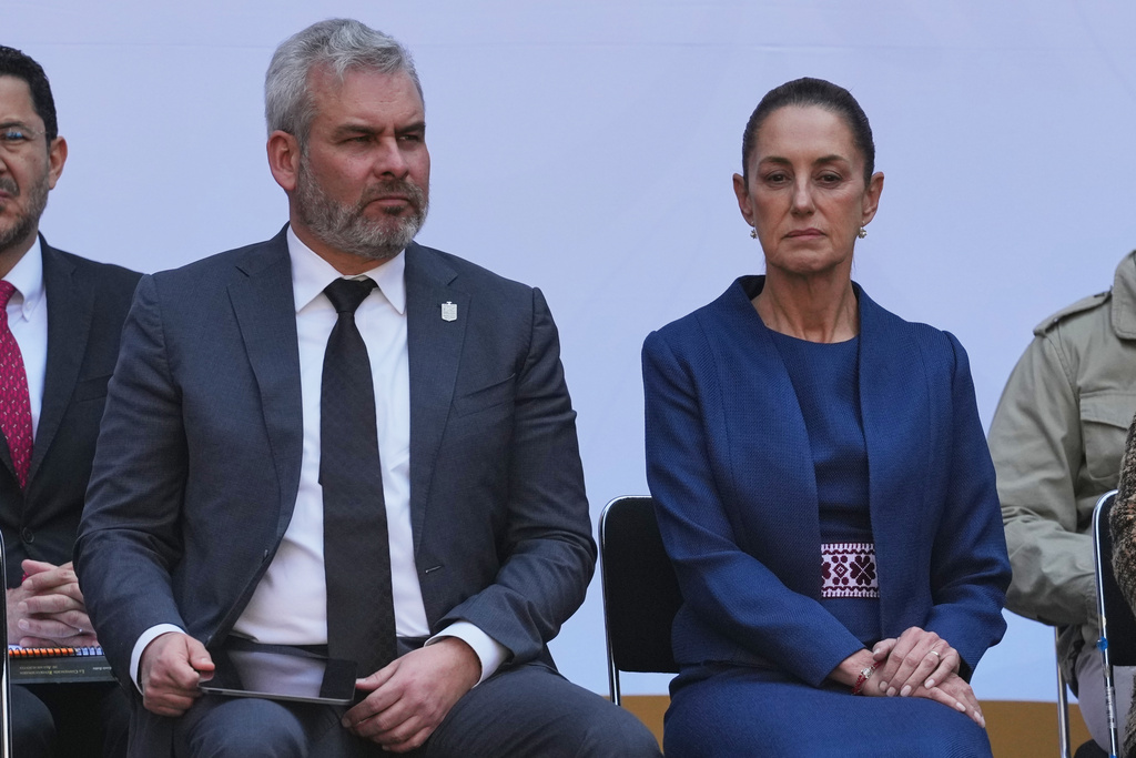 Michoacan State Governor Alfredo Ramirez Bedolla, left, and Mexican President Claudia Sheinbaum listen during the presentation of the new security strategy against violence for the state of Michoacan, at the National Palace in Mexico City, Sunday, Nov. 9, 2025. (AP Photo/Claudia Rosel)