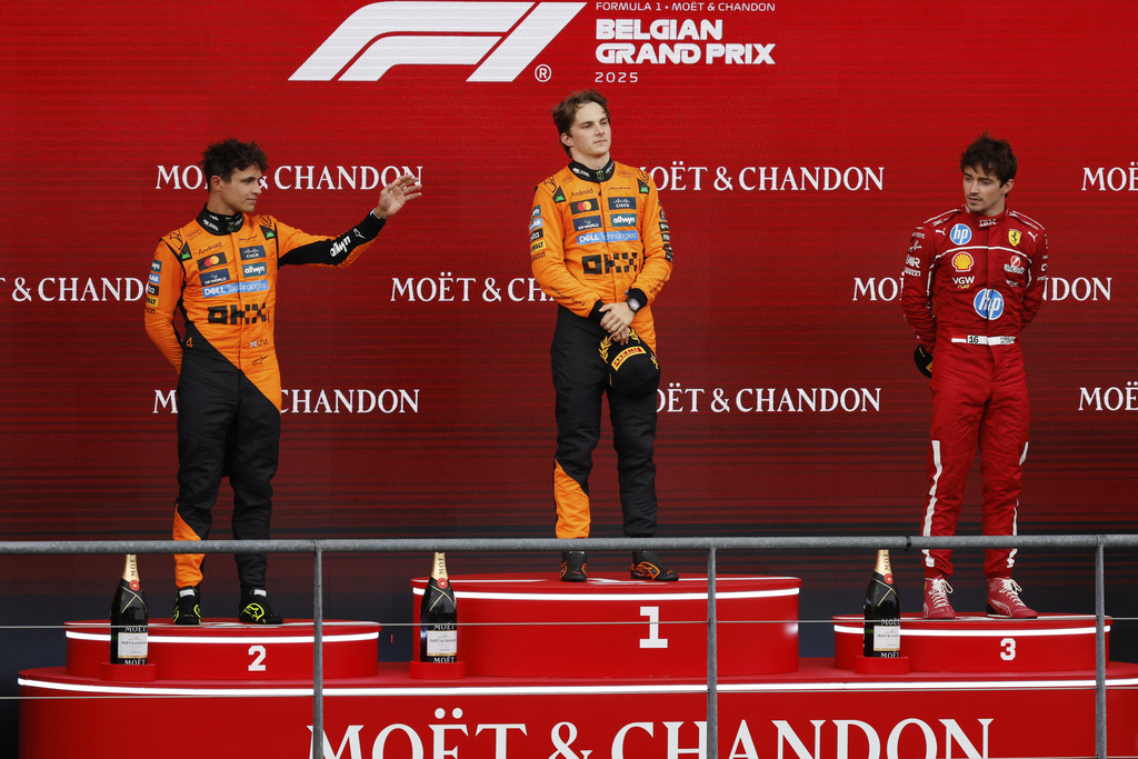First place, McLaren driver Oscar Piastri of Australia, center, celebrates on the podium with second place McLaren driver Lando Norris of Britain, left, and third place Ferrari driver Charles Leclerc of Monaco during the Formula One Grand Prix at the Spa-Francorchamps racetrack in Spa, Belgium, Sunday, July 27, 2025. (AP Photo/Geert Vanden Wijngaert)