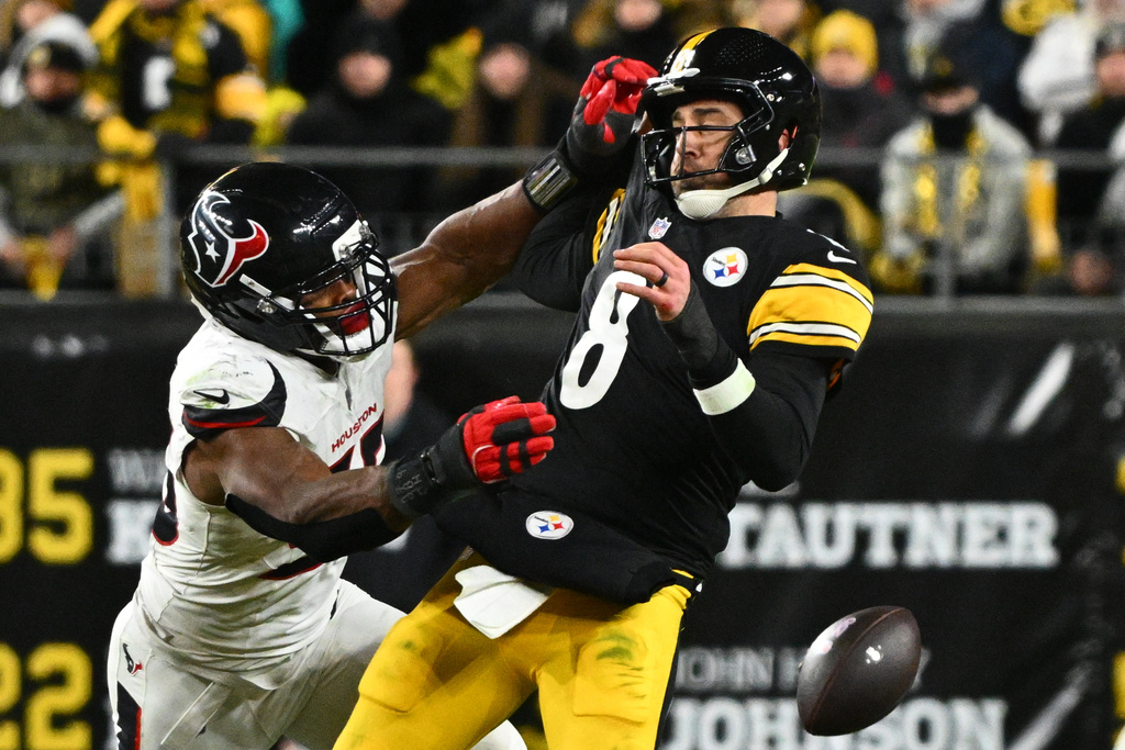 Pittsburgh Steelers quarterback Aaron Rodgers (8) loses possession of the ball while being tackled by Houston Texans defensive end Danielle Hunter (55) during the second half of an NFL wild-card playoff football game, Monday, Jan. 12, 2026, in Pittsburgh. (AP Photo/Justin Berl)