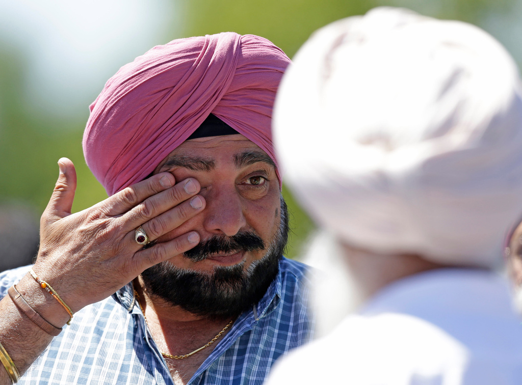 FILE - A man wipes away tears outside the Sikh Temple in Oak Creek, Wis. where a shooting took place on Sunday, Aug 5, 2012. (AP Photo/Jeffrey Phelps, File)