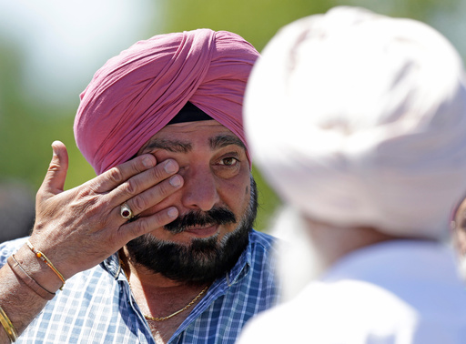 FILE - A man wipes away tears outside the Sikh Temple in Oak Creek, Wis. where a shooting took place on Sunday, Aug 5, 2012. (AP Photo/Jeffrey Phelps, File) FILE - A man wipes away tears outside the Sikh Temple in Oak Creek, Wis. where a shooting took place on Sunday, Aug 5, 2012. (AP Photo/Jeffrey Phelps, File)