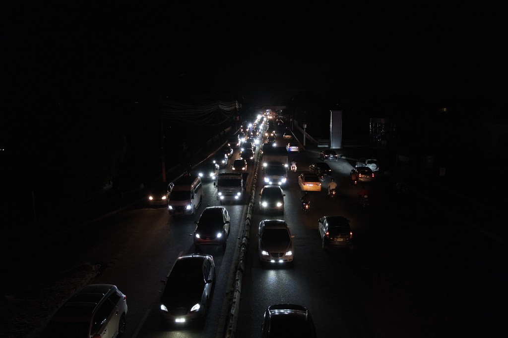 People drive vehicles during a blackout in Santo Domingo, Dominican Republic, Tuesday, Nov. 11, 2025. (AP Photo/Ricardo Hernandez)