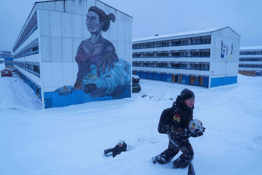 Boys play with a ball in the snow in Nuuk, Greenland, Monday, Jan. 19, 2026. (AP Photo/Evgeniy Maloletka)