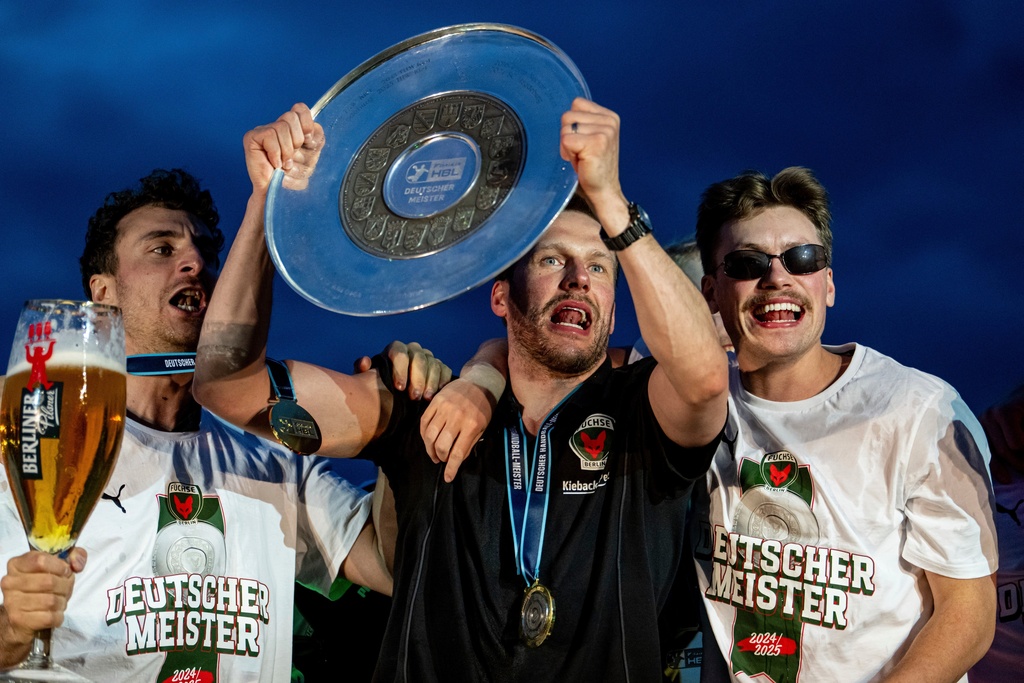 Members of Berlin's Handball team 'Die Fuechse', The Foxes, celebrate winning the German championship with the trophy in Berlin, June 8, 2025, (Fabian Somme/dpa via AP)