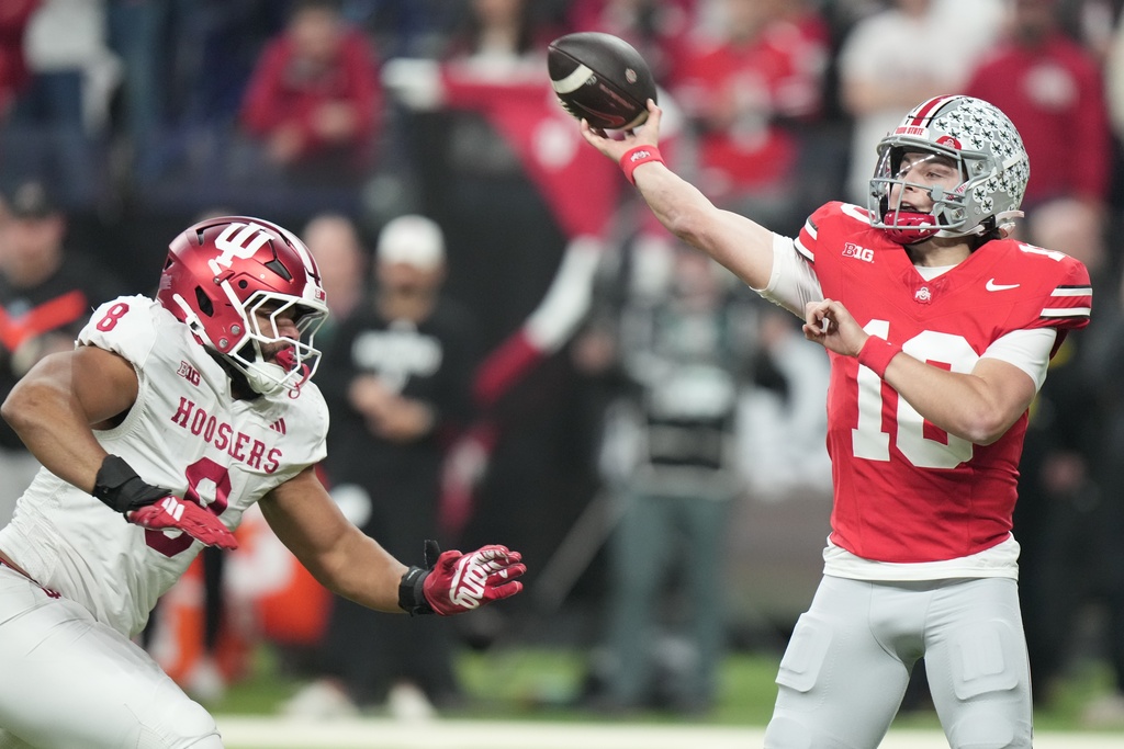 Ohio State's Julian Sayin throws with pressure from Indiana's Stephen Daley during the first half of the Big Ten championship NCAA college football game in Indianapolis, Saturday, Dec. 6, 2025. (AP Photo/AJ Mast)