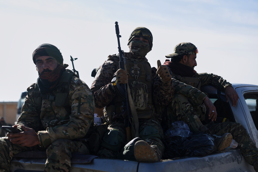 Syrian government soldiers sit atop a vehicle as they patrol inside the al-Hol camp in northeastern Syria's Hasakeh province, Syria, Wednesday, Jan. 21, 2026, after the withdrawal of the Syrian Democratic Forces (SDF). (AP Photo/Ghaith Alsayed)