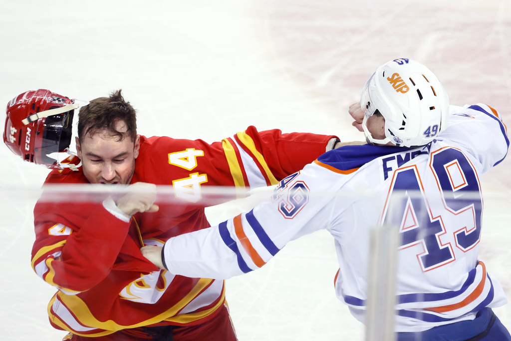 Edmonton Oilers' Ty Emberson, right, fights Calgary Flames' Joel Hanley during the second period of an NHL hockey game in Calgary, Alberta Wednesday, Feb. 4, 2026. (Larry MacDougal/The Canadian Press via AP)