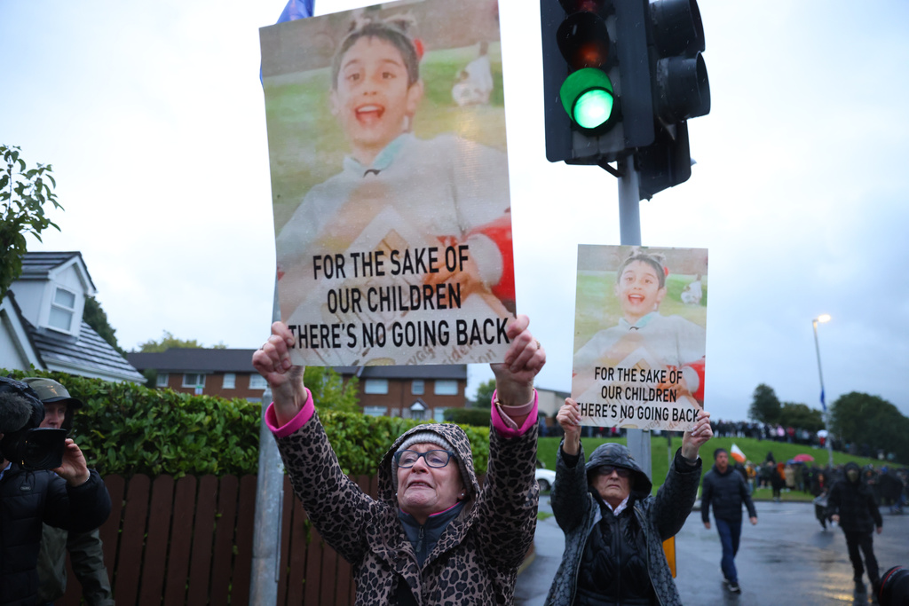 Protesters hold banners ahead of a Portadown District Loyal Orange Lodge (LOL) No 1 march in the first parade for almost 30 years, after the parade was given clearance in a late-night hearing, in Portadown, Northern Ireland, Sunday, Sept. 27, 2026. (Peter Morrison/PA via AP)
