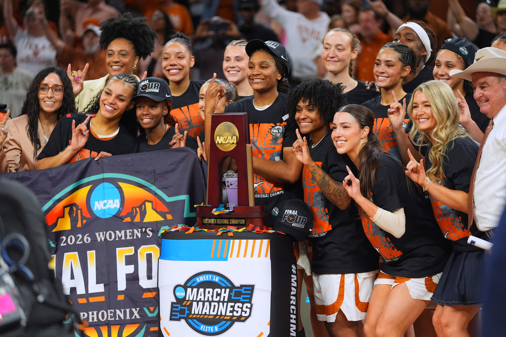 Texas players pose after beating Michigan in the Elite Eight of the NCAA college basketball tournament, Monday, March 30, 2026, in Fort Worth, Texas. (AP Photo/LM Otero)